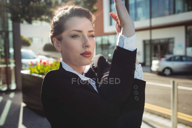 Beautiful businesswoman stretching hands on street — Stock Photo
