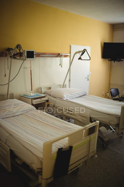 Пустое отделение с кроватями и медицинским оборудованием в больнице — стоковое фото