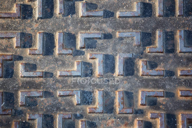 Close-up of metal pattern on surface of manhole lid — Stock Photo