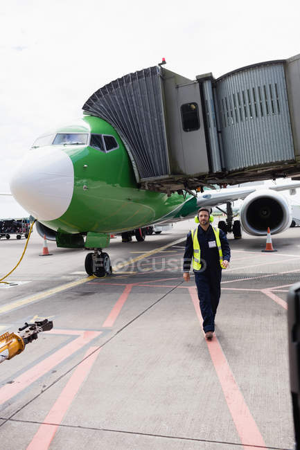 Airport ground crew walking on runway at airport terminal — Stock Photo