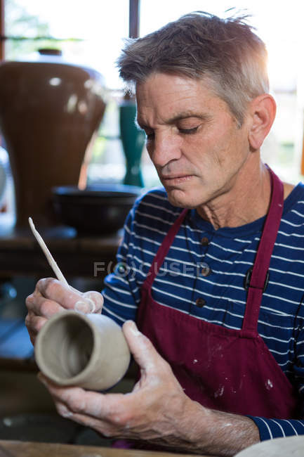 Gros plan de la sculpture de potier masculin sur pot en atelier — Photo de stock
