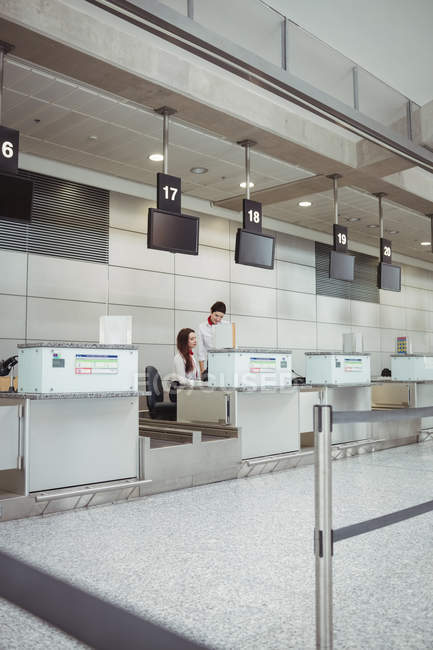 Сотрудники авиакомпании, работающие на стойке регистрации в аэропорту — стоковое фото