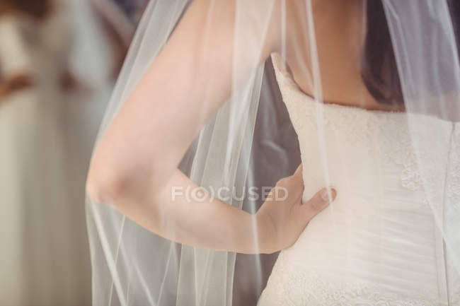 Frauenmitte probiert Hochzeitskleid im Geschäft an — Stockfoto