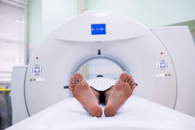 Paciente deitado em máquina de ressonância magnética em sala de digitalização no hospital — Fotografia de Stock