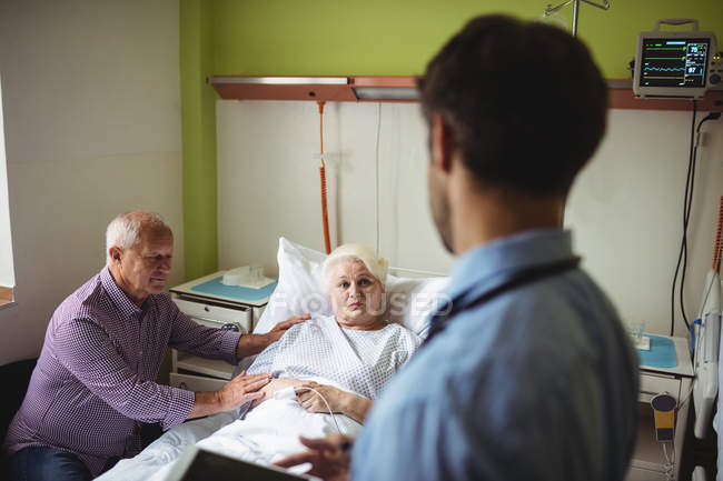 Старший пара, взаємодіючи з лікаря у відділенні лікарні — стокове фото