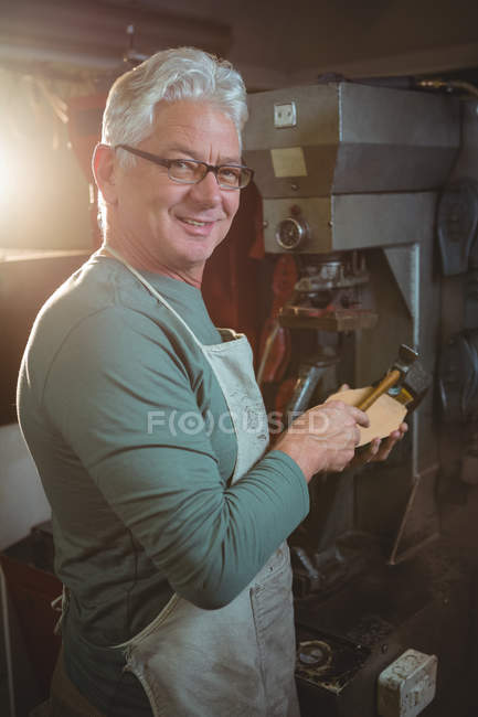Mature shoemaker hammering on a shoe in workshop — Stock Photo