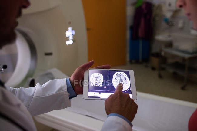 Médecin examinant le scanner IRM du cerveau sur tablette numérique à l'hôpital — Photo de stock