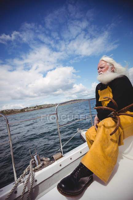 Thoughtful fisherman sitting on fishing boat — Stock Photo
