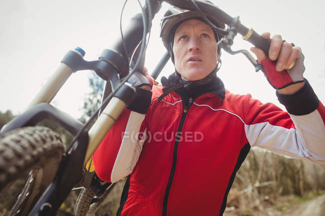 Низкий угол обзора горного велосипедиста с велосипедом — стоковое фото