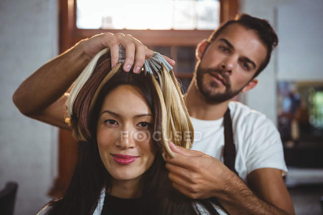 Мужчина парикмахер укладки клиентов волосы в салоне — стоковое фото