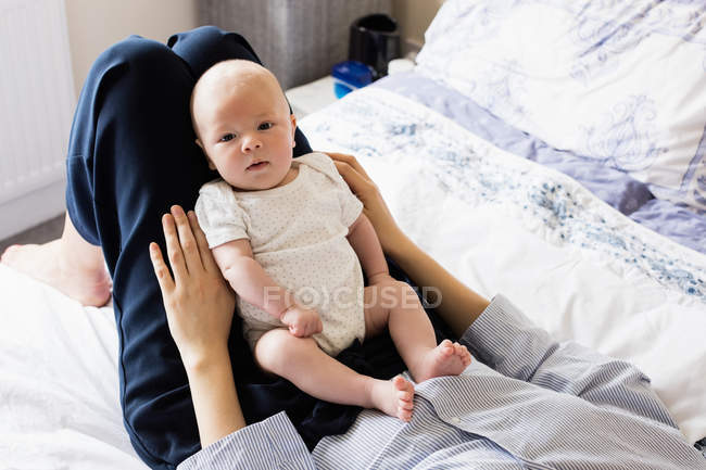 Imagen recortada de la madre jugando con el hijo en el dormitorio en casa - foto de stock