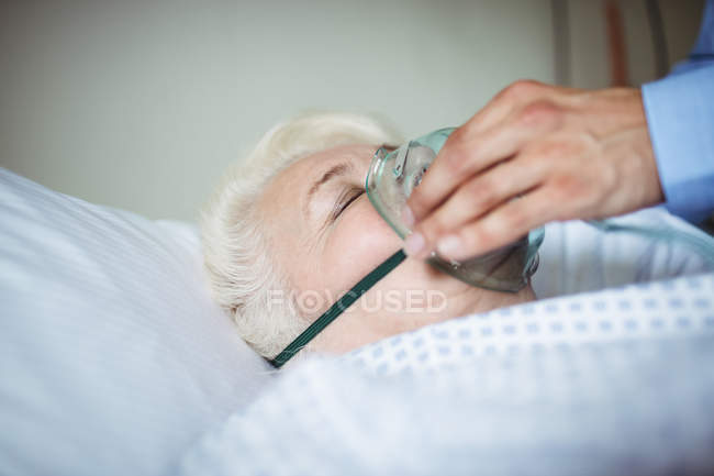 Doctor hand putting oxygen mask on patient in hospital — Stock Photo