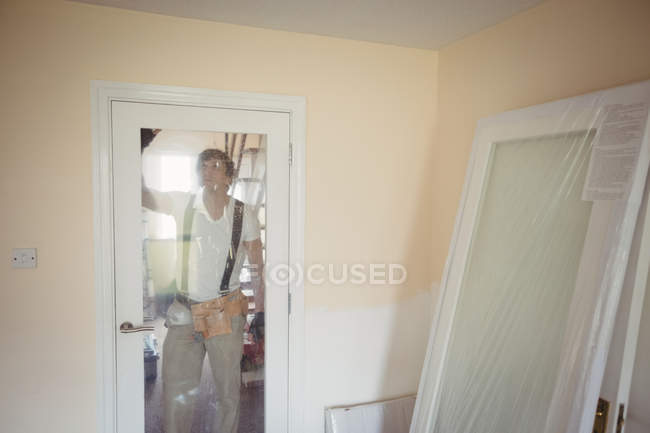 Взрослый плотник чинит дверь дома — стоковое фото