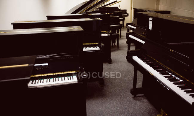 Pianos vintage dispostos no interior da oficina — Fotografia de Stock