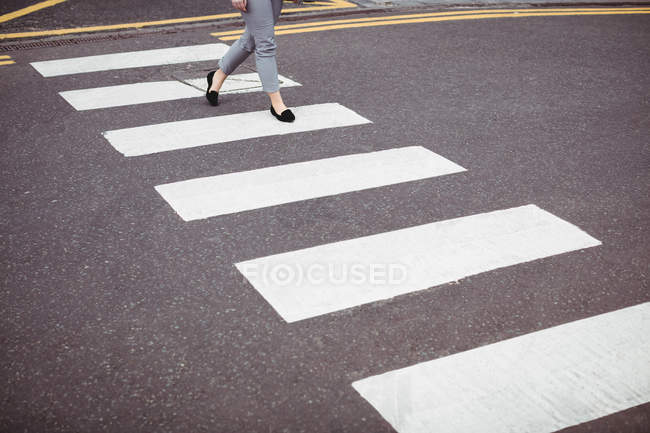 Partie basse de la femme d'affaires marchant sur la route — Photo de stock