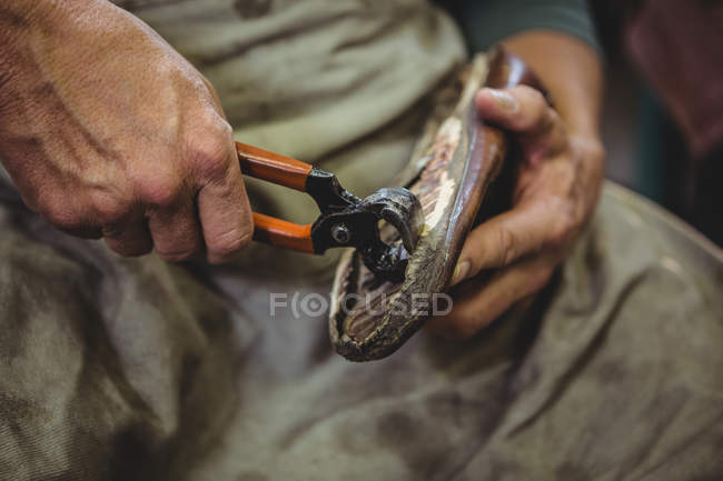Hände des Schuhmachers, der in der Werkstatt einen Schuh repariert — Stockfoto