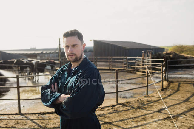 Retrato del campesino inteligente de pie contra el granero - foto de stock