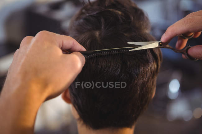 Rückansicht einer Frau, die sich im Salon die Haare schneiden lässt — Stockfoto