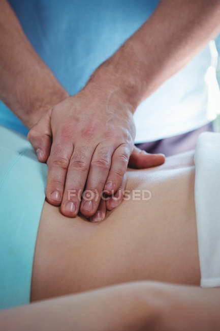 Immagine ritagliata del fisioterapista che somministra fisioterapia al dorso della paziente in clinica — Foto stock