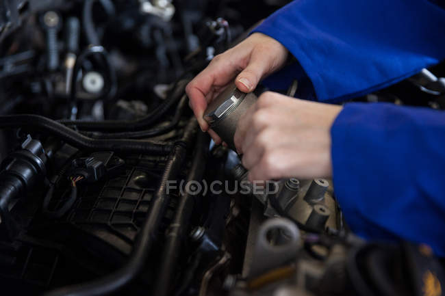 Обрезанное изображение механического обслуживания двигателя автомобиля в ремонтном гараже — стоковое фото