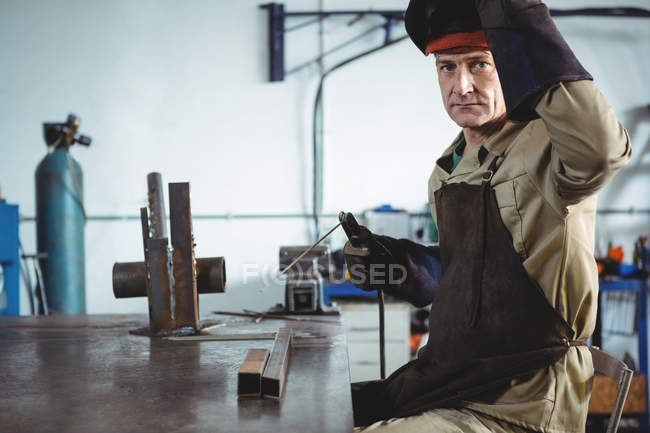 Portrait de soudeur tenant la machine à souder dans l'atelier — Photo de stock