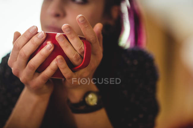 Обрезанное изображение женщины, пьющей кофе дома — стоковое фото