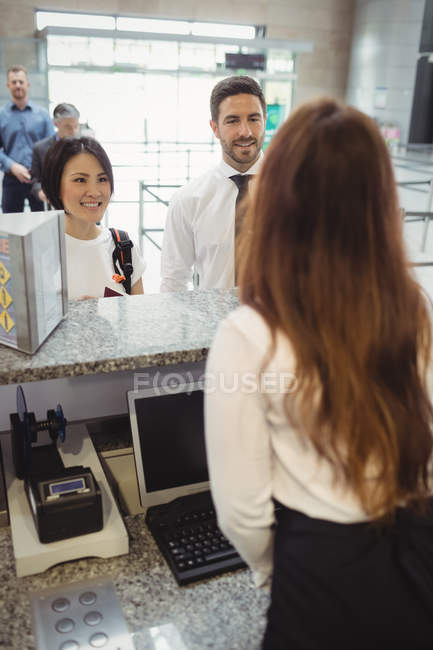 Passengers waiting in queue at check-in counter in airport terminal — Stock Photo
