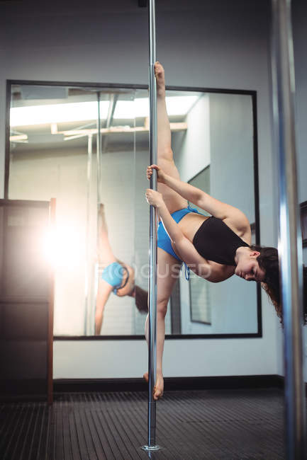 Bela dançarina Pólo praticando pole dance no estúdio de fitness — Fotografia de Stock