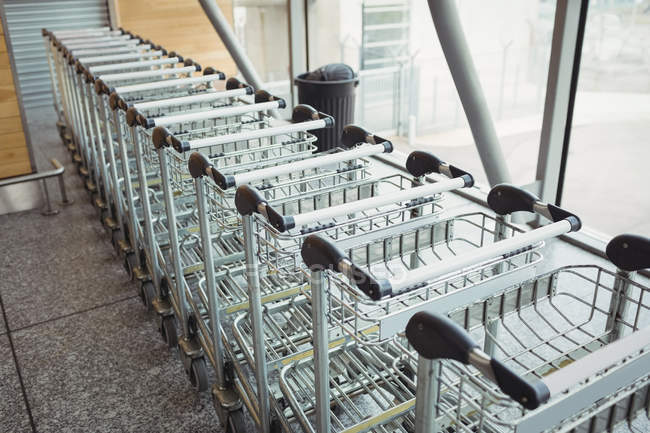 Chariots gardés en rangée dans le terminal de l'aéroport — Photo de stock