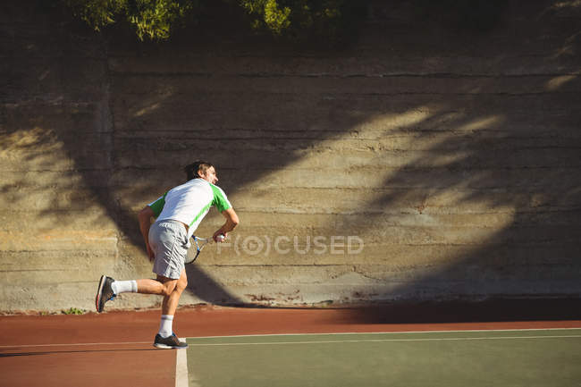 Uomo che gioca a tennis nel campo sportivo di giorno — Foto stock