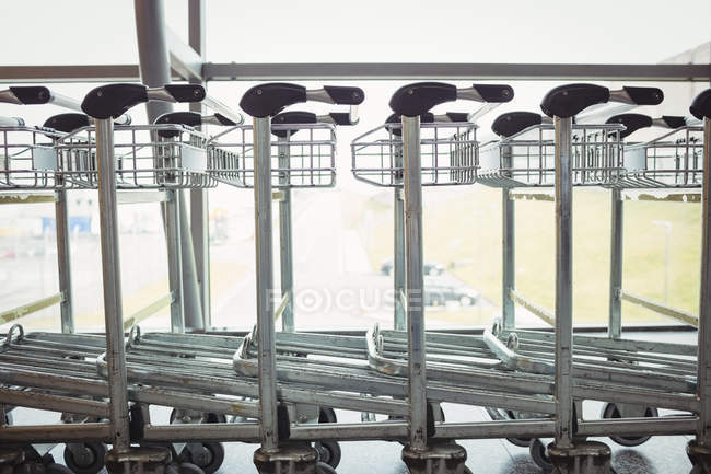 Chariots gardés en rangée dans le terminal de l'aéroport — Photo de stock