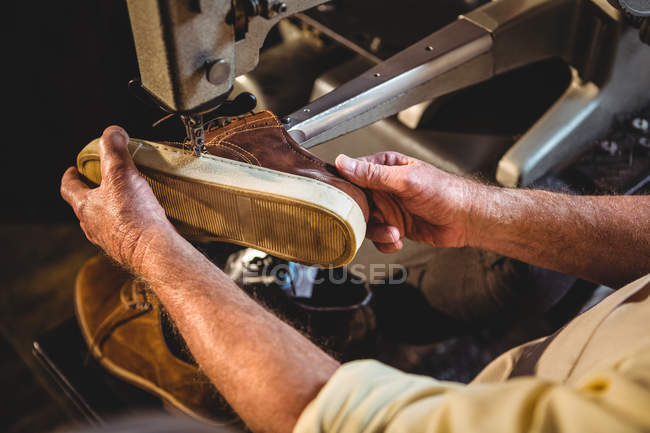 Mani di calzolaio utilizzando la macchina da cucire in officina — Foto stock