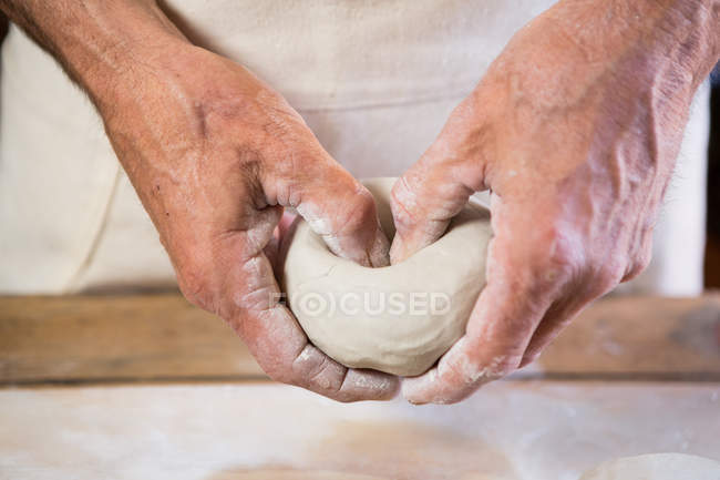 Mid section of potter molding clay in pottery workshop — Stock Photo