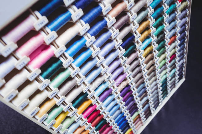 Carretéis coloridos de fios em caixa no estúdio de costura — Fotografia de Stock
