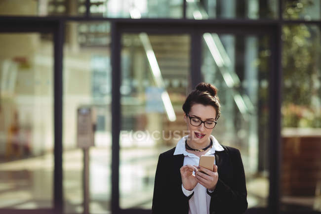 Jeune femme d'affaires utilisant un téléphone portable — Photo de stock
