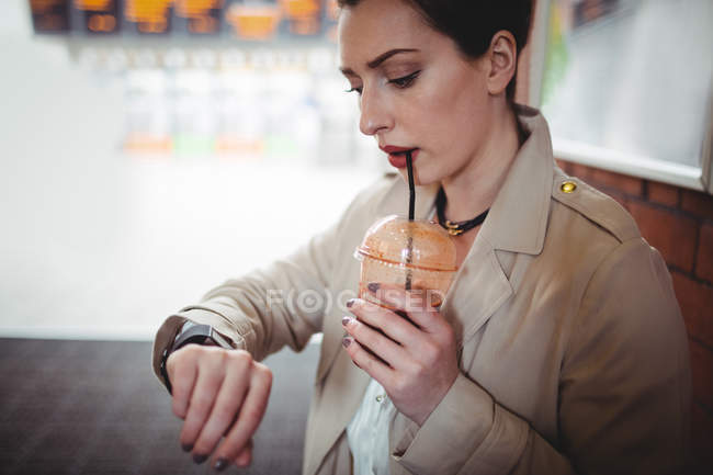 Junge Frau kontrolliert Zeit am Bahnhof — Stockfoto