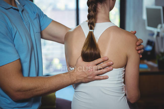 Cropped image of Physiotherapist massaging back of female patient in clinic — Stock Photo