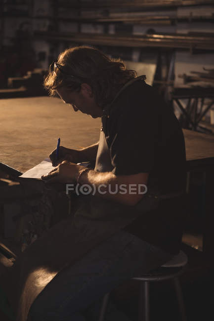 Ferreiro que prepara notas na oficina — Fotografia de Stock
