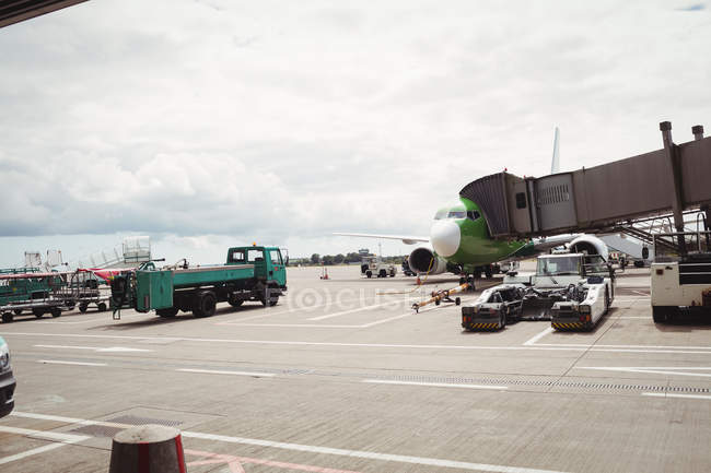 Avión con puente de carga listo para la salida en la terminal del aeropuerto - foto de stock