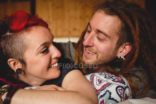 Heureux jeune couple se détendre sur le lit à la maison — Photo de stock