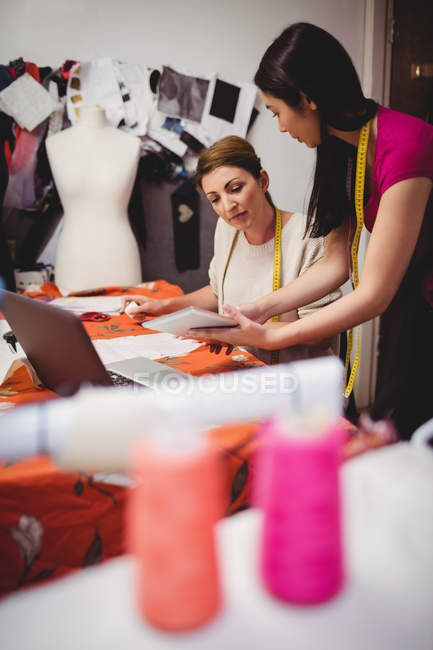 Female fashion designers working on laptop in studio — Stock Photo