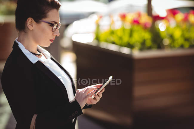 Вид сбоку на молодую предпринимательницу с помощью мобильного телефона — стоковое фото