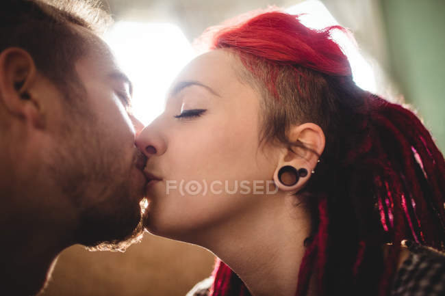 Primer plano de pareja hipster romántica besándose en casa - foto de stock