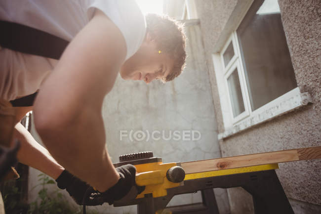 Low angle view of Carpenter polishing wooden frame with polishing machine — Stock Photo