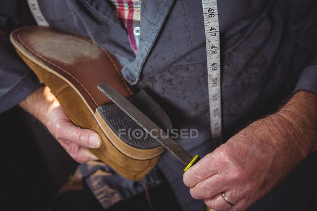 Mains de cordonnier réparer une chaussure en atelier — Photo de stock