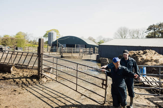 Полная длина работников фермы, открывающих ворота при входе — стоковое фото