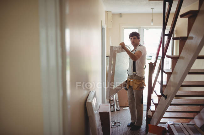 Carpintero trabajando en la puerta de madera en casa - foto de stock