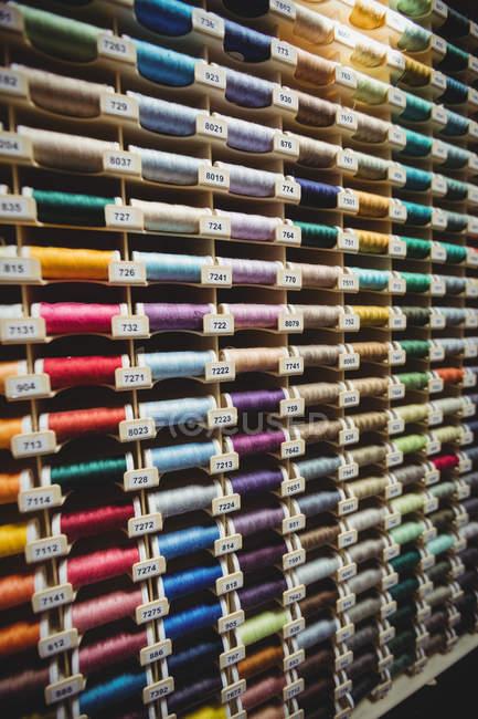 Красочные катушки нитей в коробке в швейной мастерской — стоковое фото