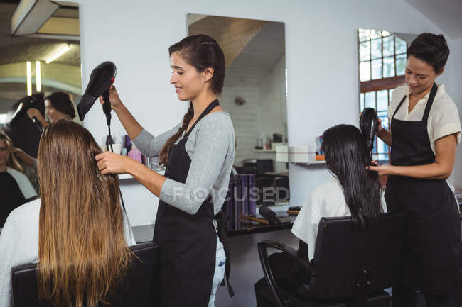 Les femmes se font sécher les cheveux avec sèche-cheveux au salon de coiffure — Photo de stock