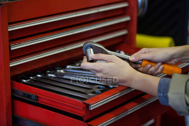Abgeschnittenes Bild des Mechanikers, der Schraubenschlüssel bei Reparaturmüll hält — Stockfoto